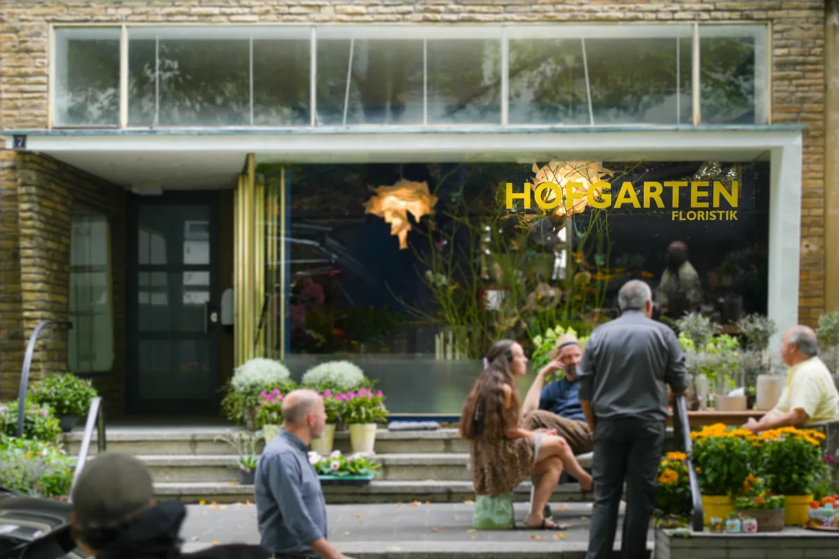 Schaufenster von Hofgarten Floristik in der Lennéstraße in Bonn mit goldener Aufschrift, davor Blumen und Stauden